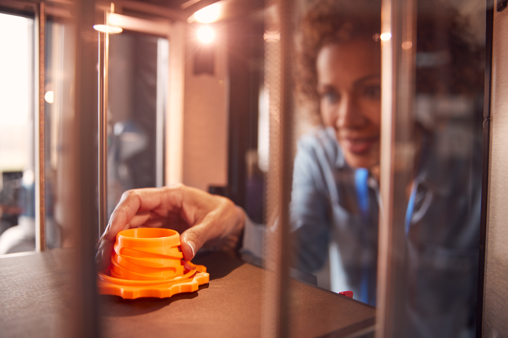 Person 3D Printing Orange Prototype Shipping Case