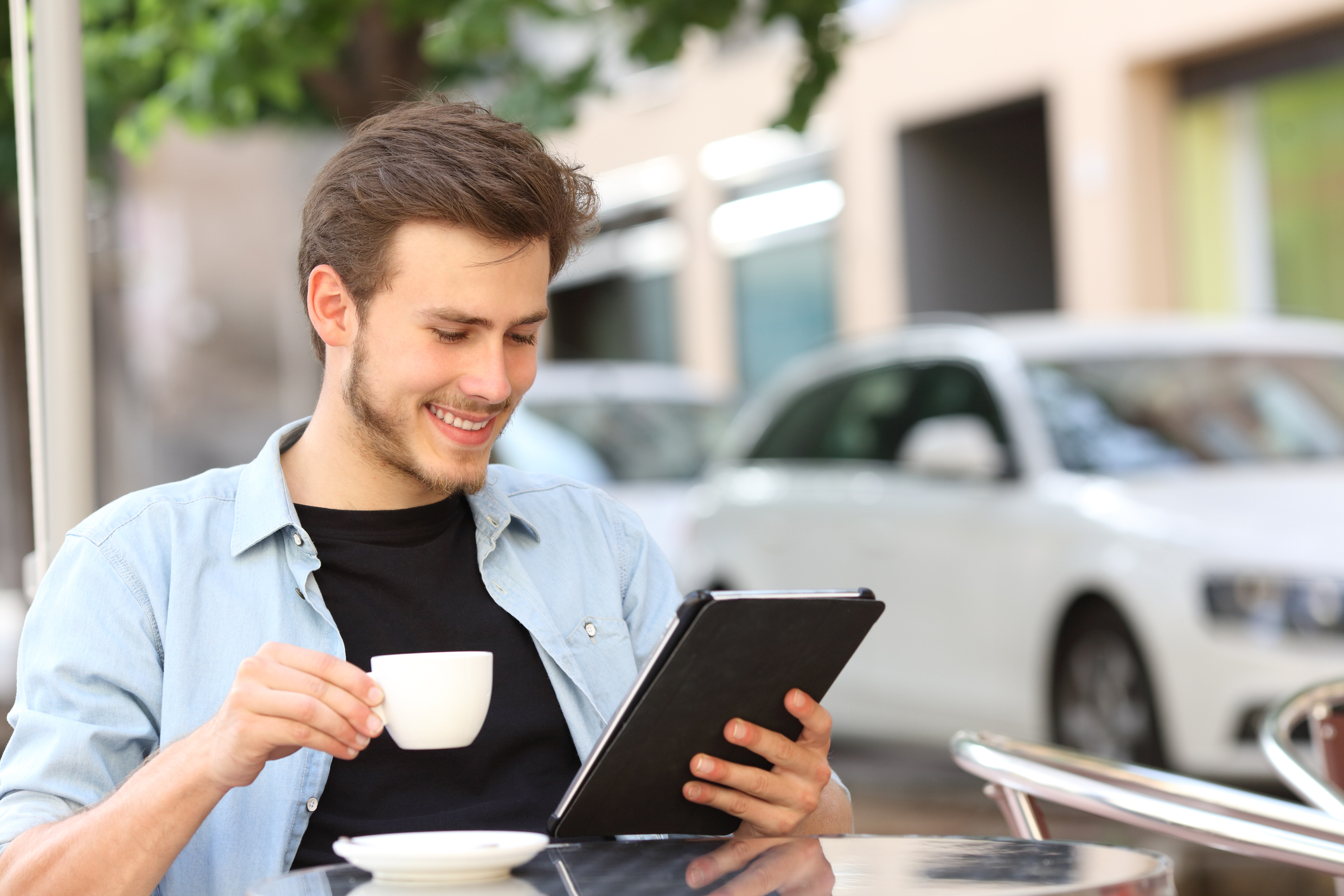 Man enjoying reading on tablet at cafe storytelling communications s