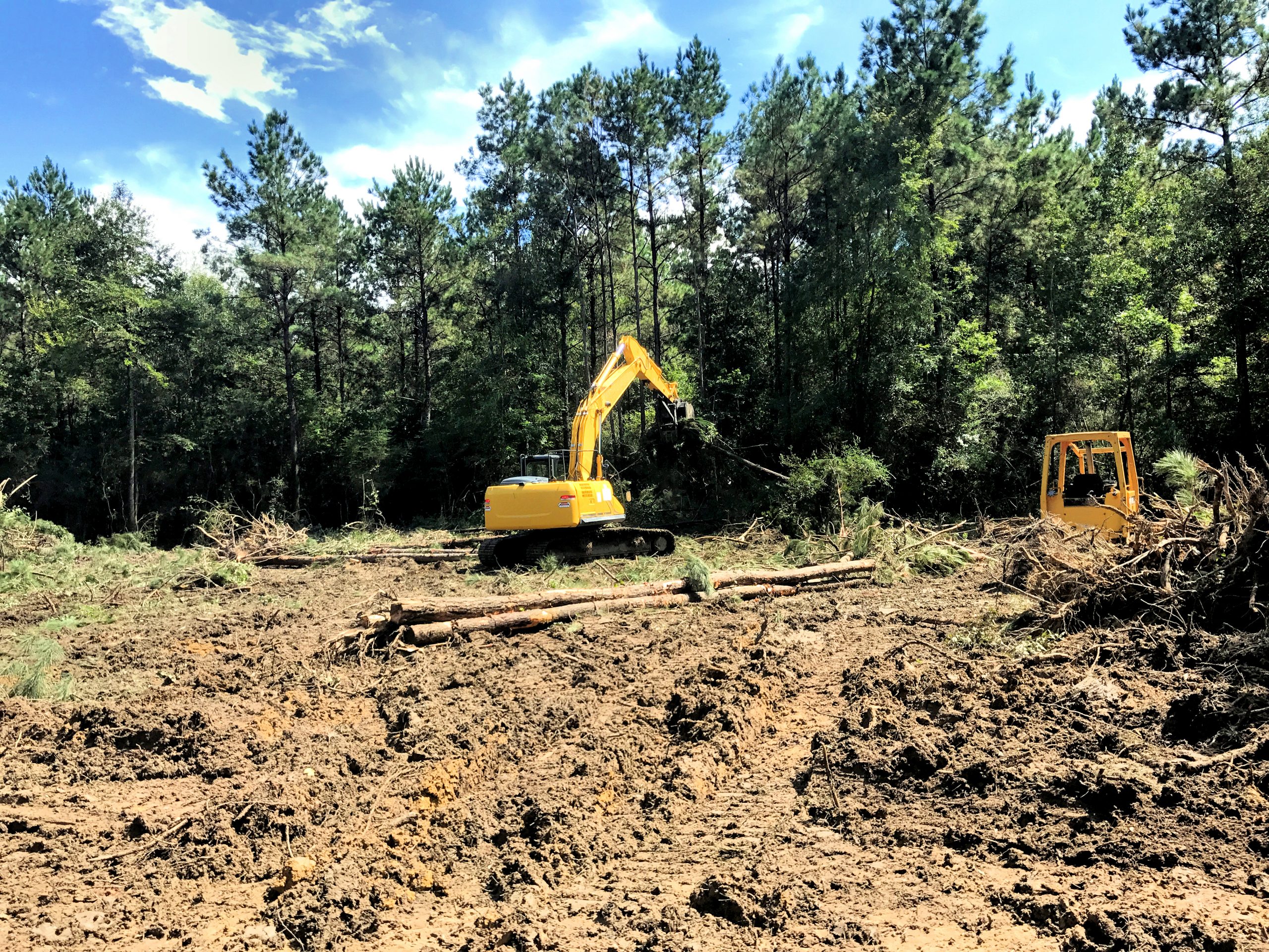 Excavator clearing a wooded lot. RC Excavation Landscape Contractor